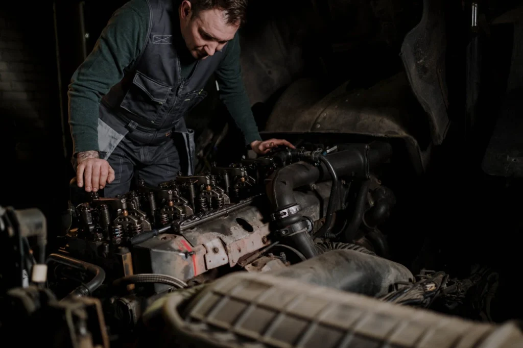 Mechanic repairing a truck engine, comprehensive auto repair services at Firestone Buckner.