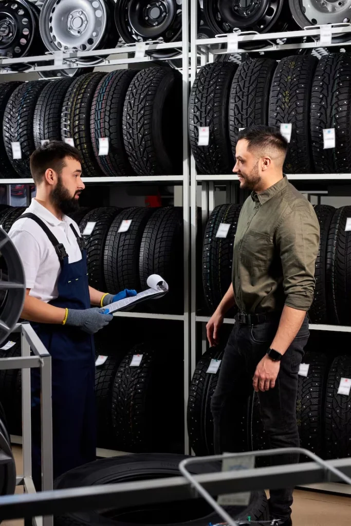 Firestone Buckner mechanic assisting customer choosing tires in auto store.